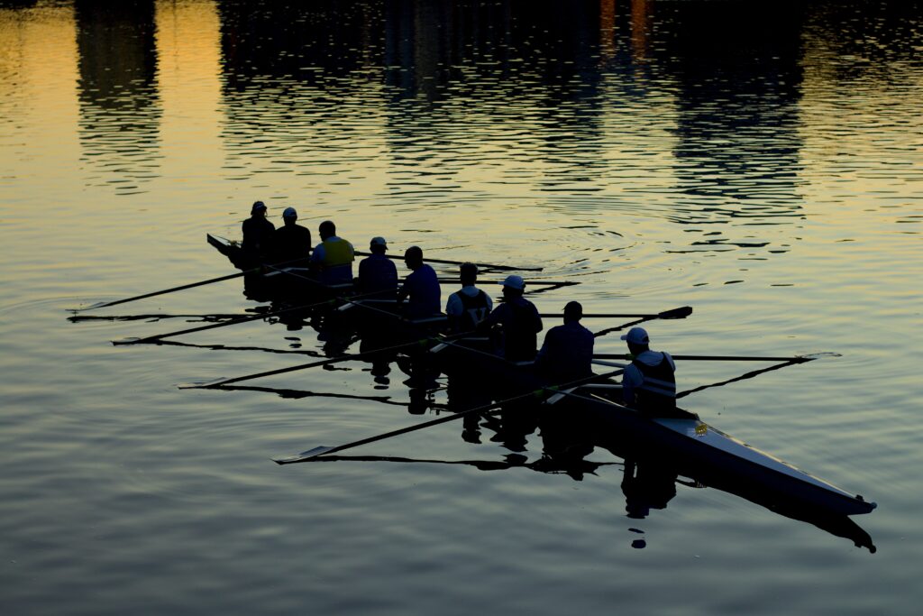 A team rowing at dusk.