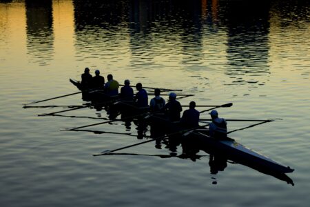 A team rowing at dusk.